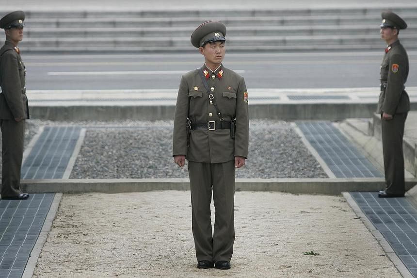 North Korean soldiers stand guard at the border of the demilitarised zone (DMZ) at Panmunjon. The concrete slab across the centre of the photo represents the border and anything beyond that is South Korea's territory. -- PHOTO: ST FILE