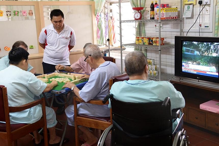 Kwong Wai Shiu Hospital patients playing mahjong and watching TV.&nbsp;Financial aid scheme Medifund paid out more money this financial year, said the Health Ministry in a statement on Wednesday. -- PHOTO: ST FILE