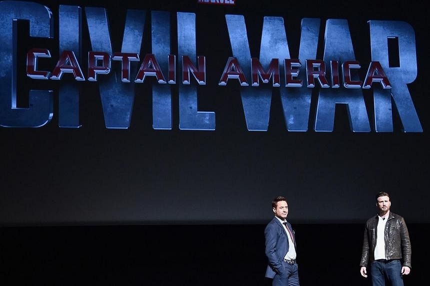 Actors Robert Downey Jr. (left) and Chris Evans onstage during a Marvel Studios fan event at The El Capitan Theatre on Oct 28, 2014 in Los Angeles, California. -- PHOTO: AFP