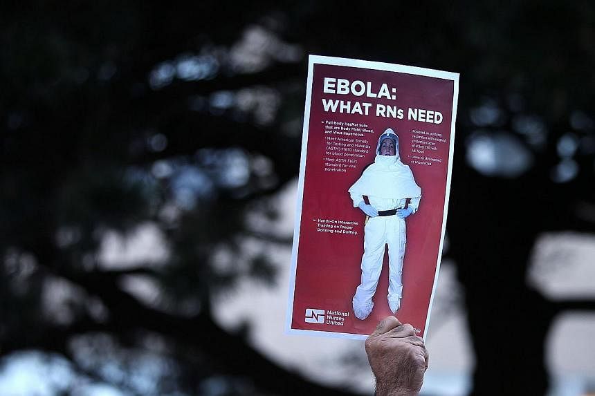 A registered nurse at the University of California Medical Center holds a sign as during a demonstration to protest inadequate Ebola preparedness at UC medical centers in San Francisco, California&nbsp;on Oct 28, 2014. -- PHOTO: REUTERS