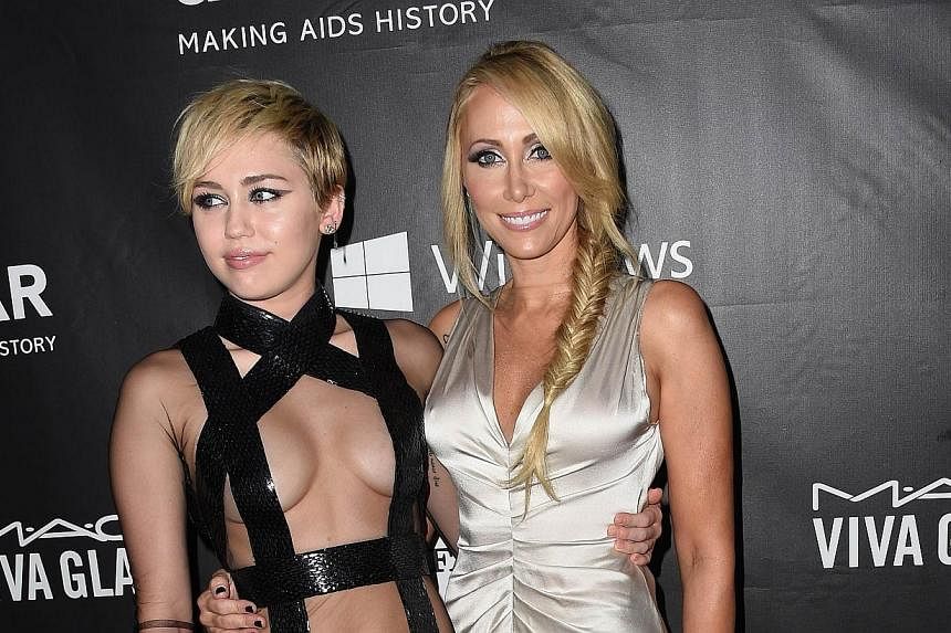 Actress Miley Cyrus (left) and her mother Tish Cyrus attend amfAR’s fifth annual Inspiration Gala in Los Angeles, Oct 29, 2014 at Milk Studios in Hollywood, California. -- PHOTO: AFP