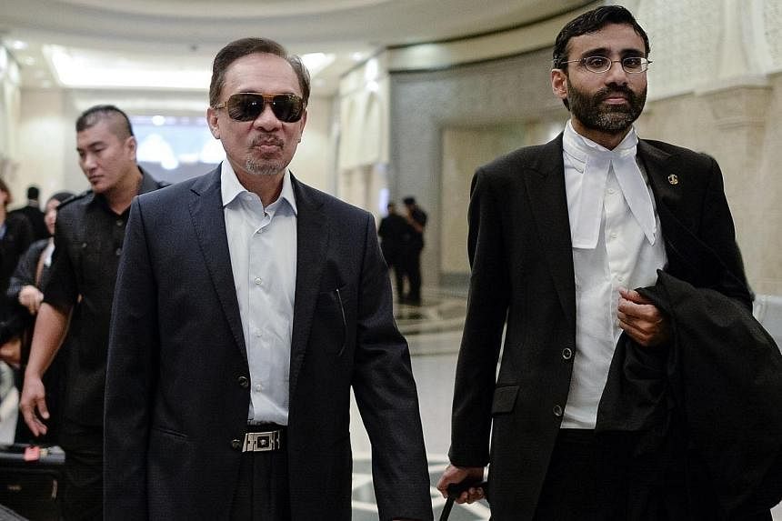 Malaysian Opposition leader Anwar Ibrahim (left) and his lawyer N. Surendran (right) arrive at the federal court in Putrajaya on Oct 30, 2014. -- PHOTO: AFP