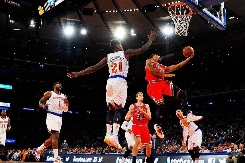 Derrick Rose #1 of the Chicago Bulls attempts a lay up under Iman Shumpert #21 of the New York Knicks in the second quarter during a game at Madison Square Garden on Oct 29, 2014 in New York City. -- PHOTO: AFP