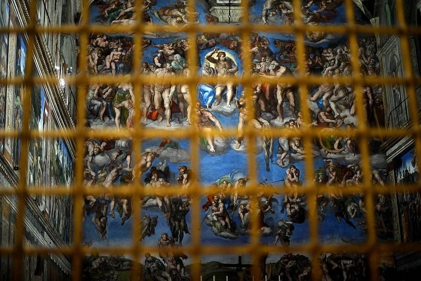 The Sisitne Chapel with its new lighting is seen through a fence during a press visit at the Vatican on Oct 29, 2014.&nbsp;High above the altar in the Vatican's Sistine Chapel, the halo around Jesus Christ's head in Michelangelo's famous frescoes shi