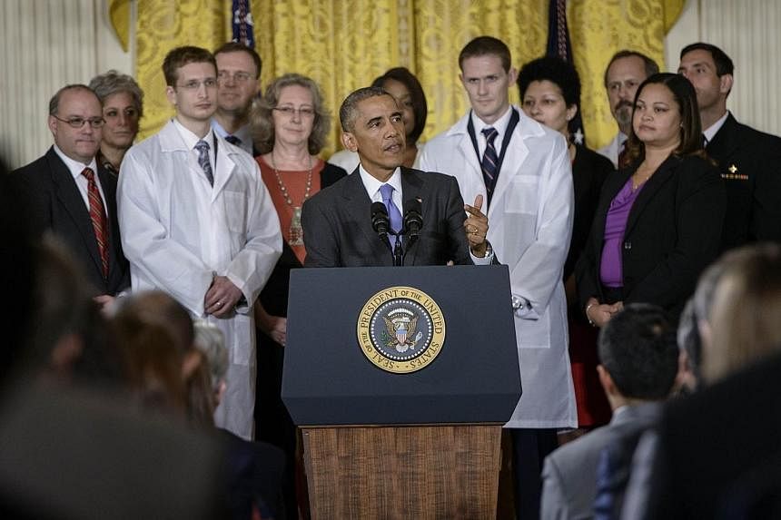 Health-care workers listen while US President Barack Obama speaks in the east room of the White House on Oct 29, 2014, in Washington, DC, where he&nbsp;hailed "heroic" US health workers battling Ebola, seeking to reassure the public amid controversy 