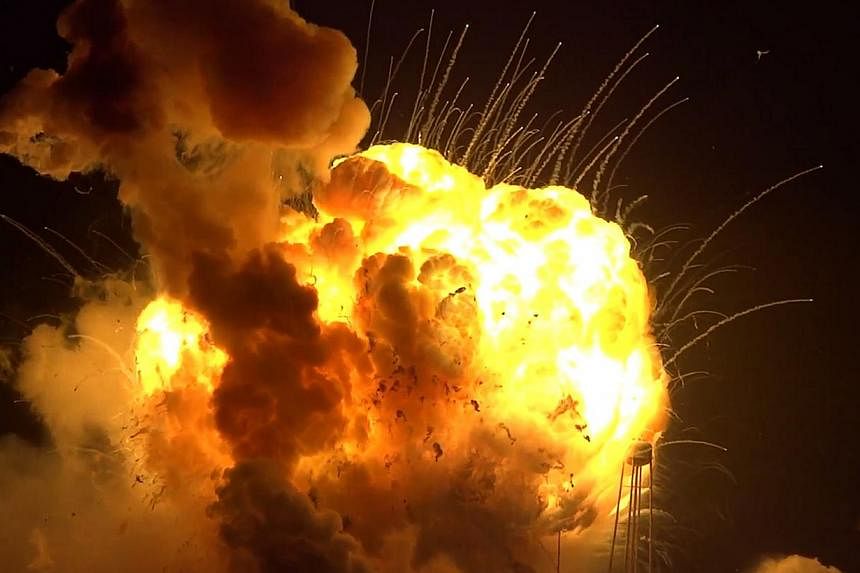 Video images showing the unmanned Antares rocket blasting off and then bursting into flames about 11 seconds after lift-off (above). -- PHOTOS: AGENCE FRANCE-PRESSE, REUTERS