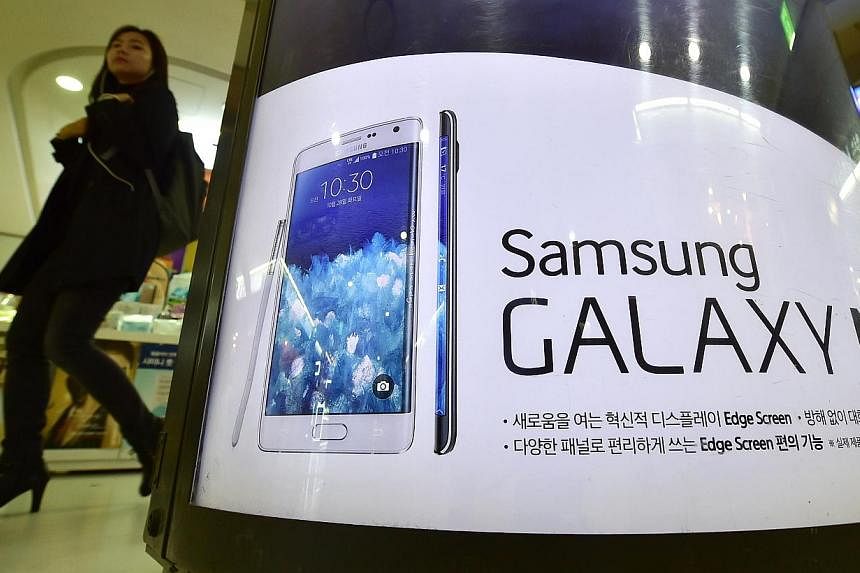 A woman walks past an advert for Samsung Galaxy Note Edge in Seoul on Oct 30, 2014. -- PHOTO: AFP