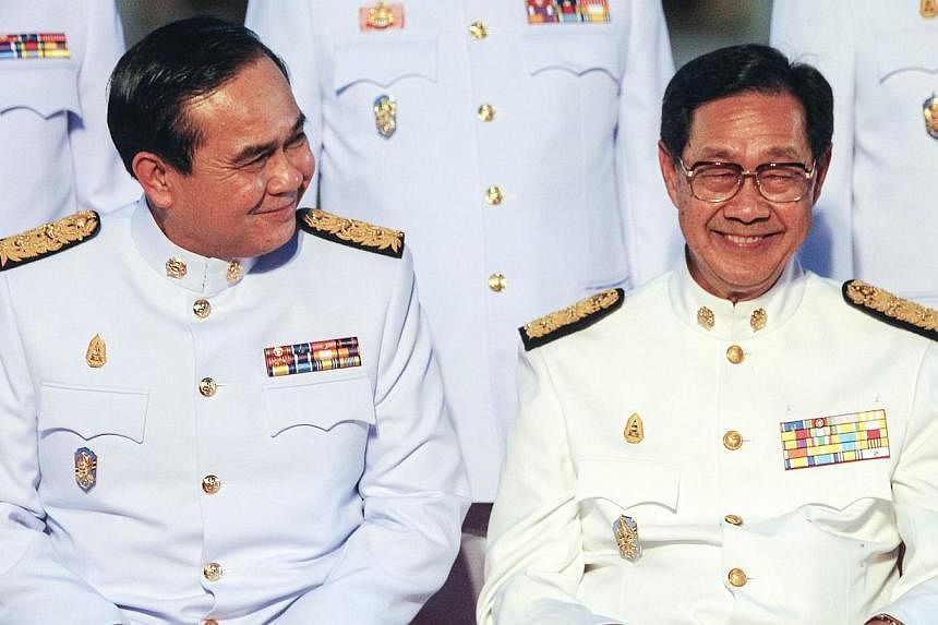 Thailand's Prime Minister Prayuth Chan-ocha (L) and Deputy Prime Minister Pridiyathorn Devakula smile during a photo session at Government House in Bangkok on Sept 4, 2014. -- PHOTO: REUTERS