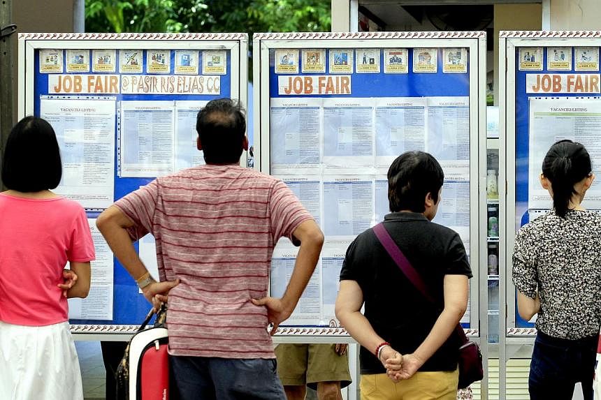 People looking at job listings displayed on boards at a recruitment drive for Pasir Ris-Punggol residents on 3 May, 2014. Singapore's seasonally adjusted unemployment rate dipped to 1.9 per cent last quarter, according to preliminary figures released