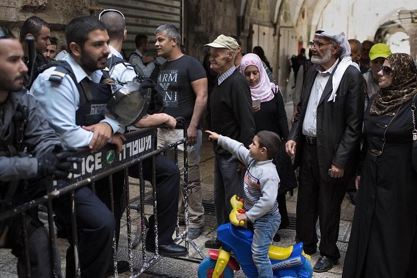 Israeli border policemen prevent Palestinians from entering the Al-Aqsa mosque compound in the old city of Jerusalem on Oct 30, 2014 after Israeli authorities temporarily closed it. -- PHOTO: AFP
