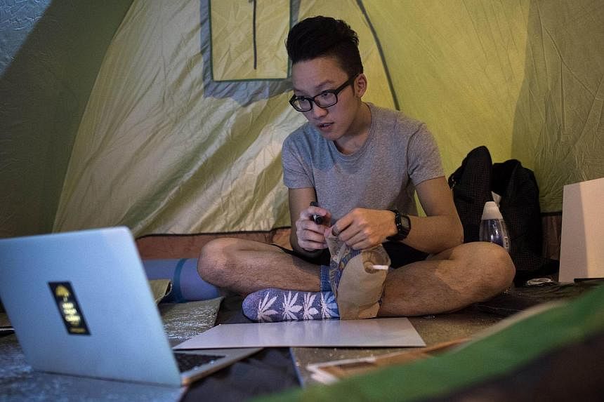 A pro-democracy protester uses a laptop as he sits inside his tent in the Admiralty district of Hong Kong. A month on the streets has given young protesters a taste of life outside the city's cramped shoebox apartments - and away from the prying eyes