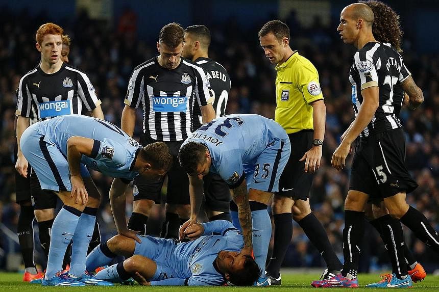 Players look at Manchester City's David Silva as he lies injured during their English League Cup fourth round soccer match against Newcastle United at the Etihad Stadium in Manchester, northern England on Oct 29, 2014.&nbsp;Manchester City midfielder