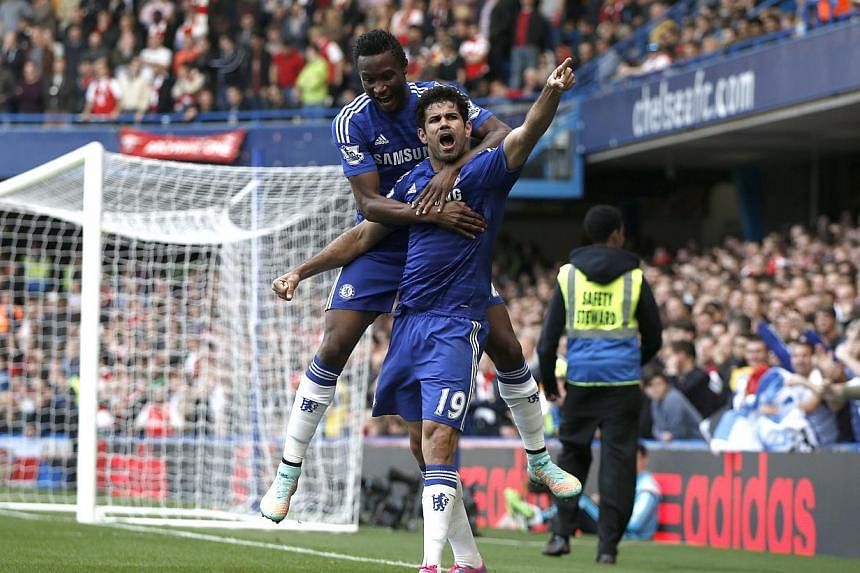 Chelsea's Brazilian-born Spanish striker Diego Costa celebrates scoring their second goal with Chelsea's Nigerian midfielder John Obi Mikel (up) during the English Premier League football match between Chelsea and Arsenal at Stamford Bridge in London