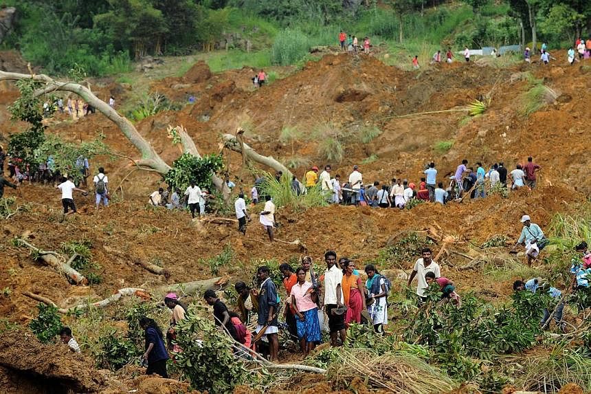 Sri Lanka residents search at the site of a landslide caused by heavy monsoon rains in Koslanda village in central Sri Lanka on Oct 30, 2014.&nbsp;Sniffer dogs were brought in on Friday to join the search for bodies at a tea plantation in Sri Lanka, 