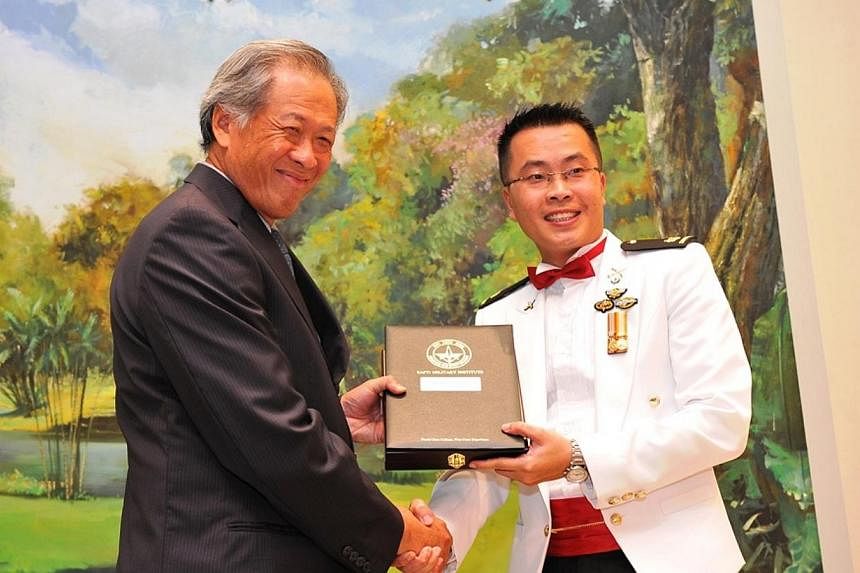 Dr Ng presenting the top Army graduate award to Major Koh Poh Hui during the presentation ceremony.&nbsp;-- PHOTO: MINDEF