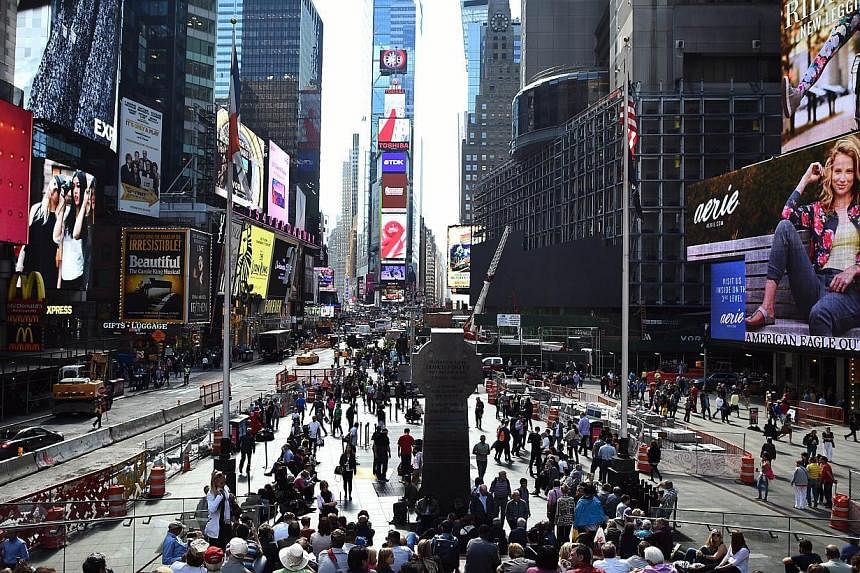 Tourists enjoy the atmosphere in Times Square in New York&nbsp;on Oct 8, 2014. -- PHOTO: AFP