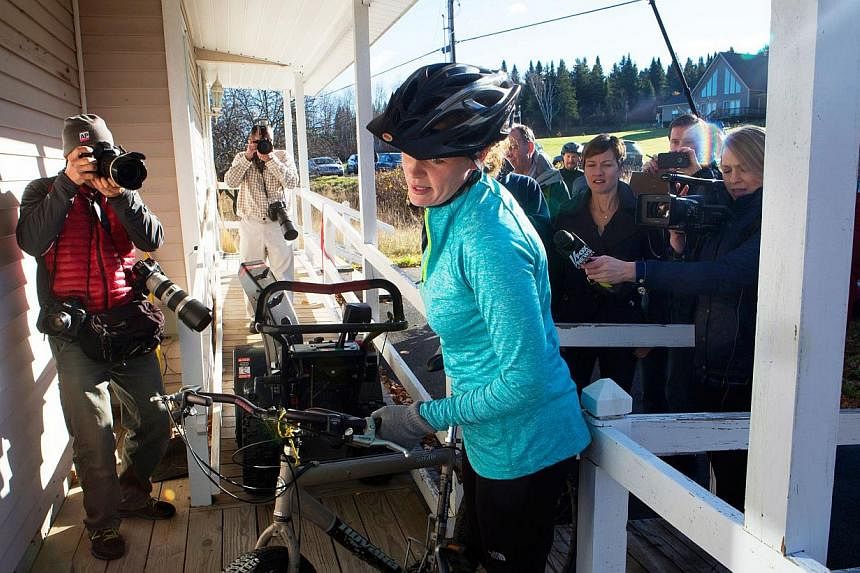 Kaci Hickox (centre) returns to her home surrounded by media after going for a bike ride with boyfriend Ted Wilbur in Fort Kent, Maine Oct 30, 2014.&nbsp;The confrontation between the state of Maine andHickox, &nbsp;a nurse who treated Ebola patients