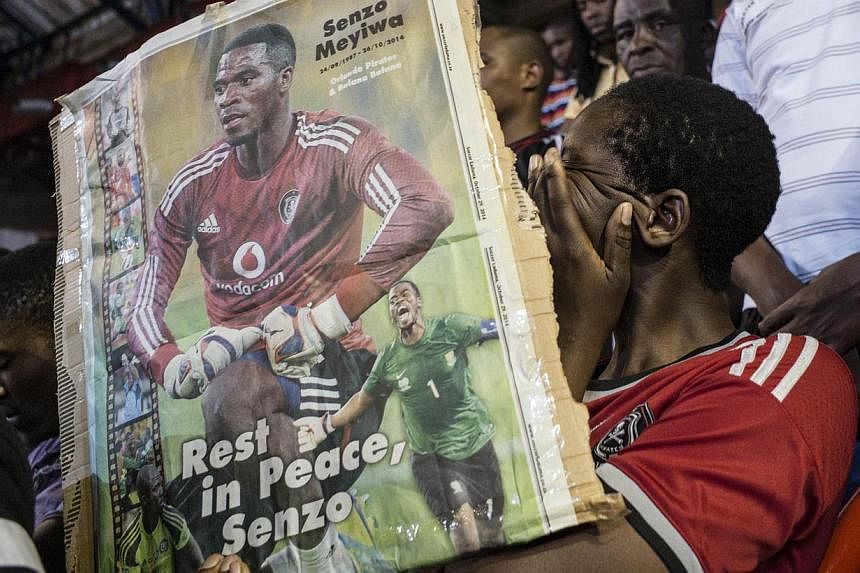 A fan cries holding a portrait of slain South African football captain Senzo Meyiwa&nbsp;during a memorial service in Johannesburg on Oct 30, 2014.&nbsp;A suspect appeared in court on Friday over the murder of Meyiwa, whose death during a robbery has