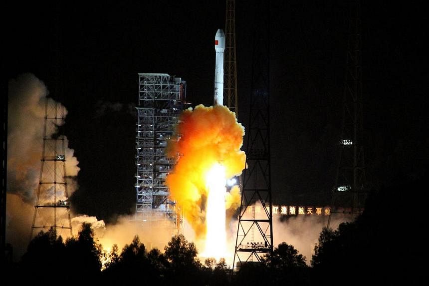 A rocket carrying an experimental spacecraft launches from Xichang space base in Xichang, south-western China's Sichuan province, on October 24, 2014. -- PHOTO: AFP