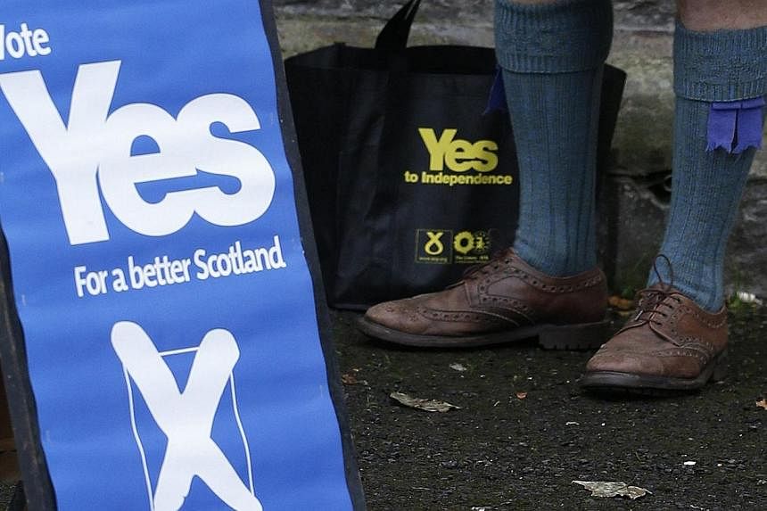 A supporter of the 'Yes' campaign stands outside a polling station during the referendum on Scottish independence in Pitlochry, Scotland on Sept 18, 2014. A majority of Scots would back independence if another referendum were held today, according to