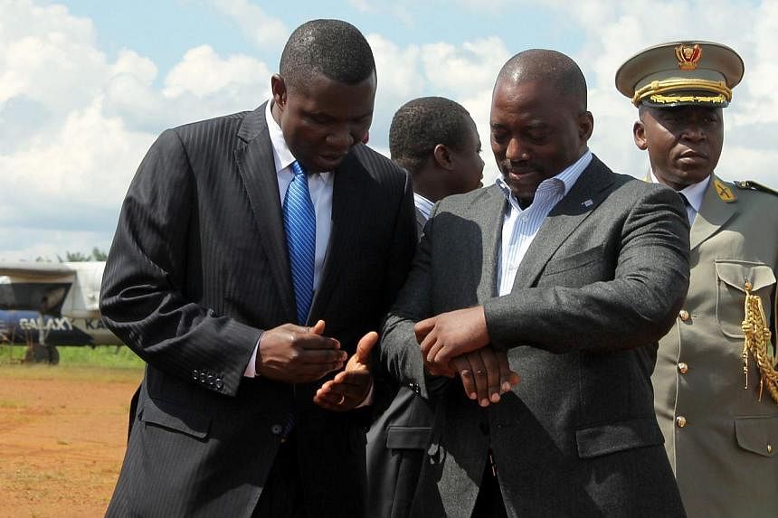 Congolese President Joseph Kabila (centre) checks his watch on Oct 29, 2014 as he arrives at the Mavivi airport in Beni, some 12kms north of the eastern city of Goma, an area where over 80 civilians were killed with machetes by Ugandan-based Allied D