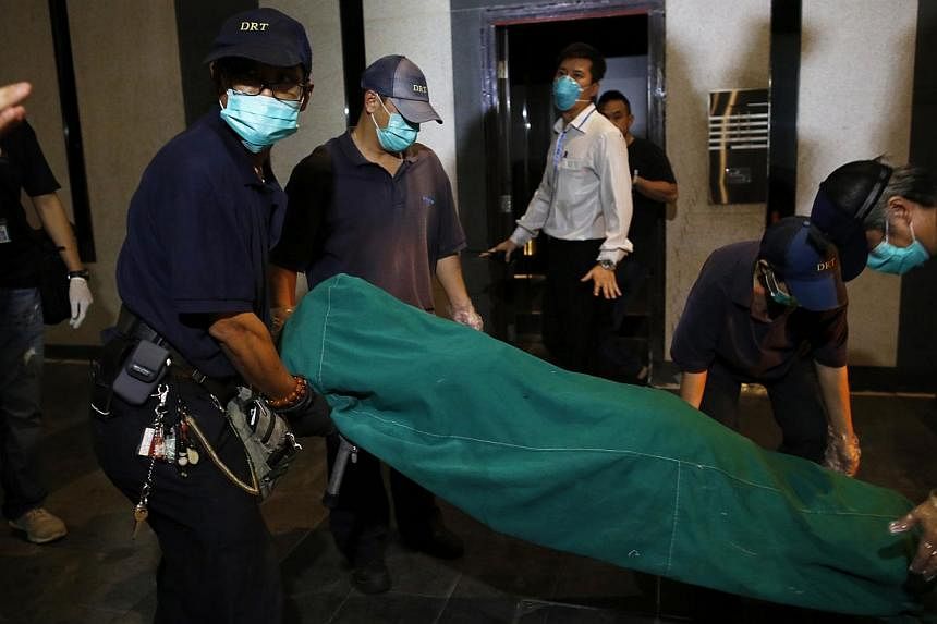 Government workers remove the body of a woman who was found dead at a residential flat at Hong Kong's Wanchai district on Nov 1, 2014. -- PHOTO: REUTERS