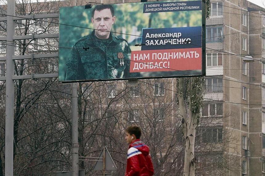A man walks past an election information board with portrait of Alexander Zakharchenko, separatist leader of the self-proclaimed Donetsk People's Republic, in Donetsk, eastern Ukraine, Nov 1, 2014. -- PHOTO: REUTERS&nbsp;