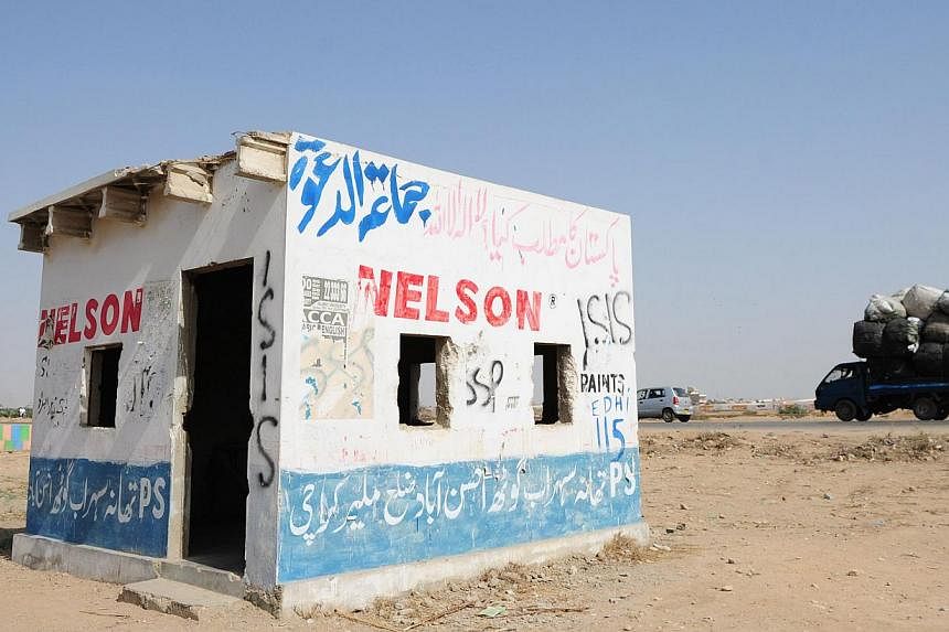 An empty police post defaced with Isis graffiti in Karachi. -- PHOTO: AFP