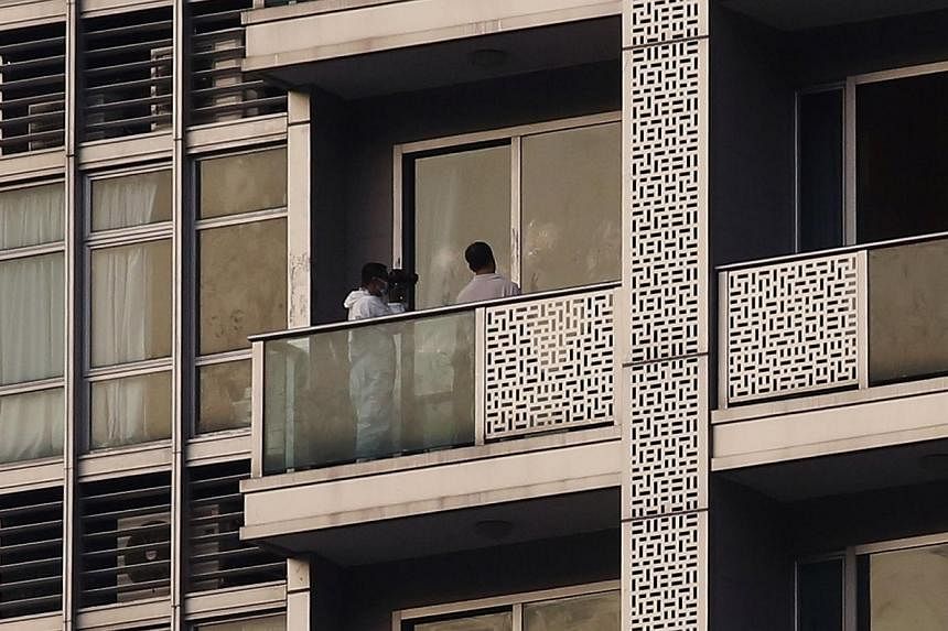 A policeman takes a photo on the balcony of a unit in which two women's bodies were found in a flat at Hong Kong's Wanchai district on Nov 1, 2014.&nbsp;Hong Kong police on Sunday questioned a 29-year-old British man who works for Bank of America Mer