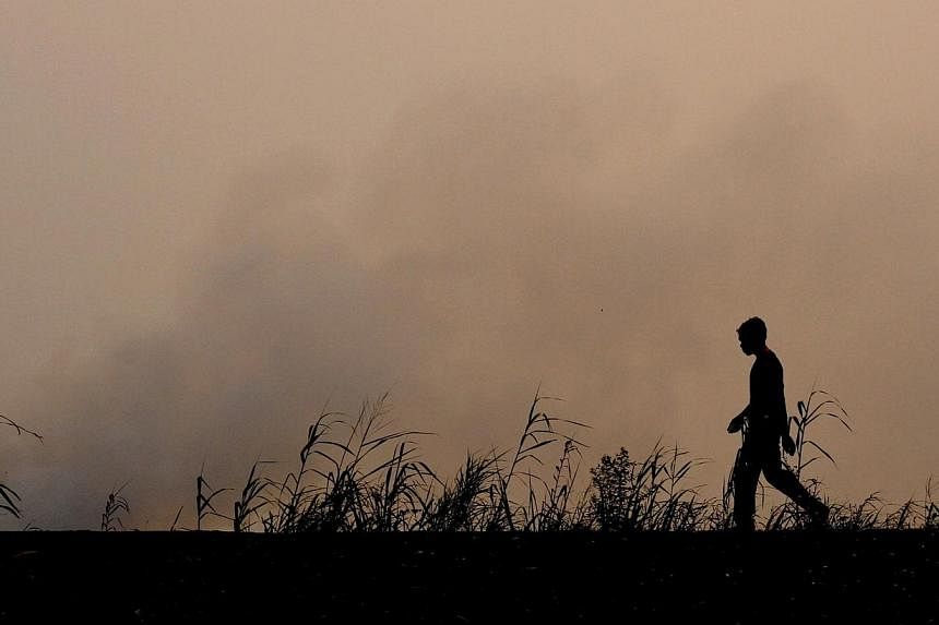 This picture taken in Ogan Ilir on Sept 11, 2014 shows an Indonesian firefighter walking on farm land where fire was raging in Ogan Ilir, South Sumatra.&nbsp;Haze from forest and plantation fire in Central Kalimantan and South Sumatra have intensifie