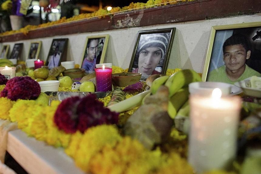 Photographs of the slain and missing students from the Ayotzinapa Teacher Training College Raul Isidro Burgos are seen in an altar in the town of Tixtla, in the southern state of Guerrero on Oct 31, 2014. -- PHOTO: REUTERS