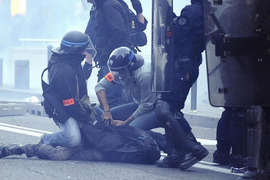 Police officers arrest a protester during clashes following a demonstration in memory of Remi Fraisse, who died in the early hours on Oct 26 during violent clashes between security forces and protesters against a controversial dam project, in Toulous