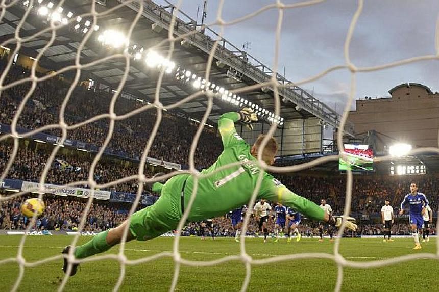 Chelsea's Eden Hazard (right) shoots to score a penalty against Queens Park Rangers during their English Premier League soccer match at Stamford Bridge in London Nov 1, 2014. Hazard's penalty enabled Chelsea to preserve their four-point lead in the P