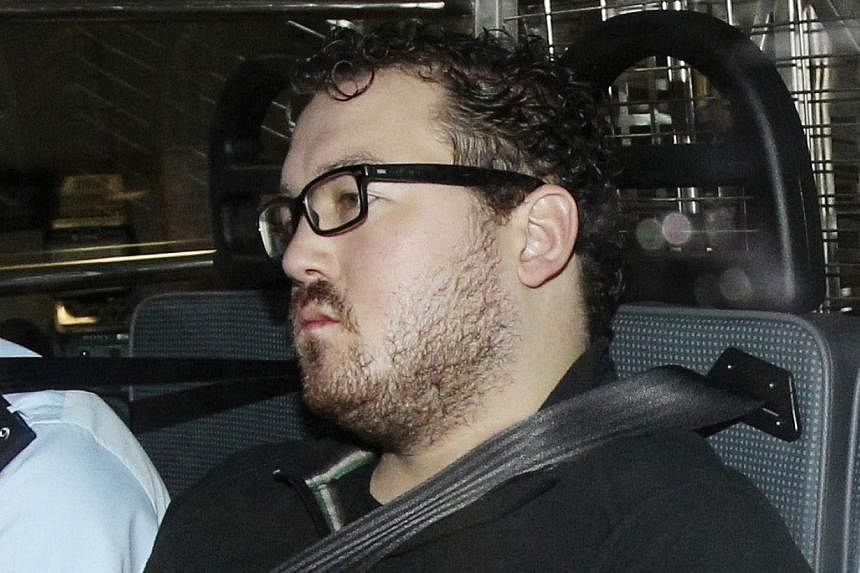 Rurik Jutting, a 29-year-old British banker who has been charged with two counts of murder, sits in a police van as it arrives at a court in Hong Kong on Nov 3, 2014. PHOTO: REUTERS&nbsp;