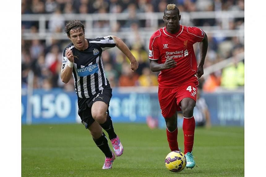 Newcastle United's Daryl Janmaat (left) challenges Liverpool's Mario Balotelli during their English Premier League football match at St James' Park in Newcastle, northern England on Nov 1, 2014. -- PHOTO: REUTERS