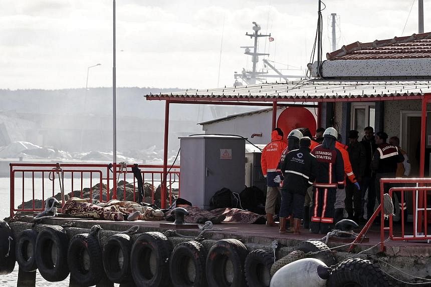 Rescue workers stand beside bodies retrieved from the sea after a boat sank in the Bosphorus strait, near Istanbul on Nov 3, 2014.&nbsp;At least 24 illegal migrants drowned on Monday when a boat taking them towards European Union waters sank in the B