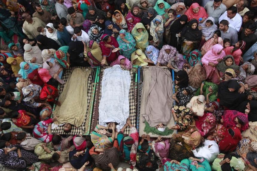 Relatives gathering on Monday beside the bodies of victims who were killed on Sunday's suicide bomb attack on the Wagah border, before funeral prayers in Lahore. At least 45 people were killed on Sunday when a suicide bomber blew himself up on the Pa