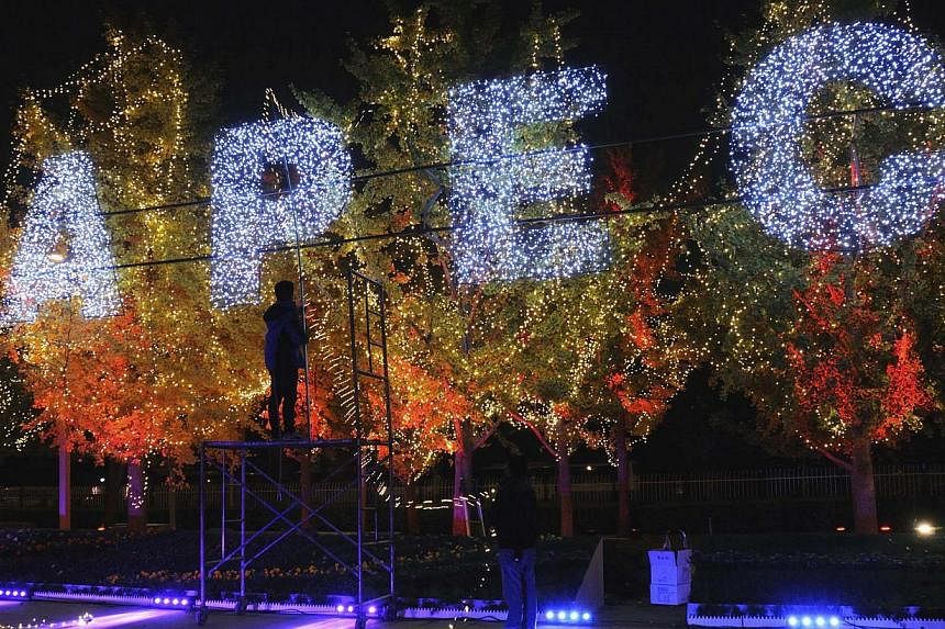 Workers set up decorative lights on trees for the upcoming APEC Summit, at the Olympic Park in Beijing on October 30, 2014. --PHOTO: REUTERS
