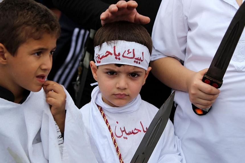 Iraqi Shiite boys take part in a self-flagellation ceremony during a parade ahead of Ashura. -- PHOTO: AFP