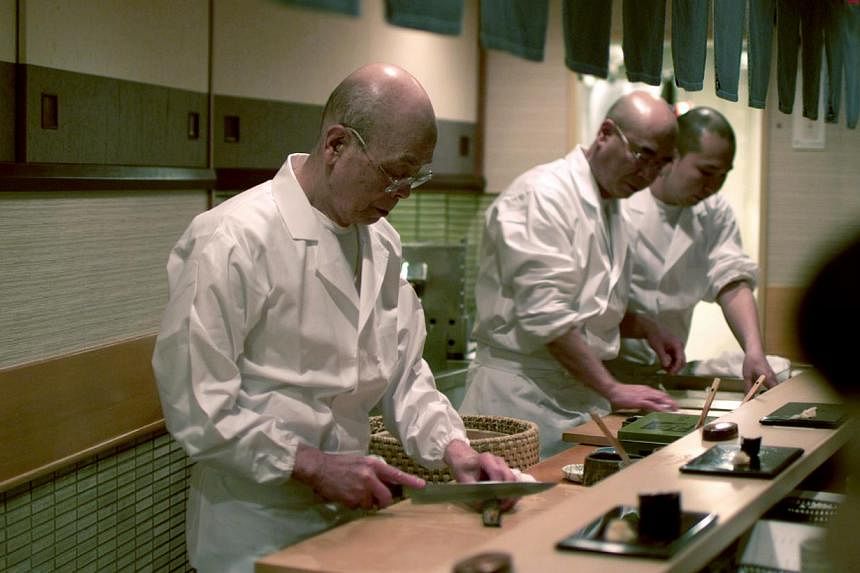 Master sushi chef Jiro Ono and his team creating sushi. He shot to international fame when the Michelin guide gave his modest sushi bar the highest accolade of three stars. -- PHOTO: PREFERRED CONTENT&nbsp;