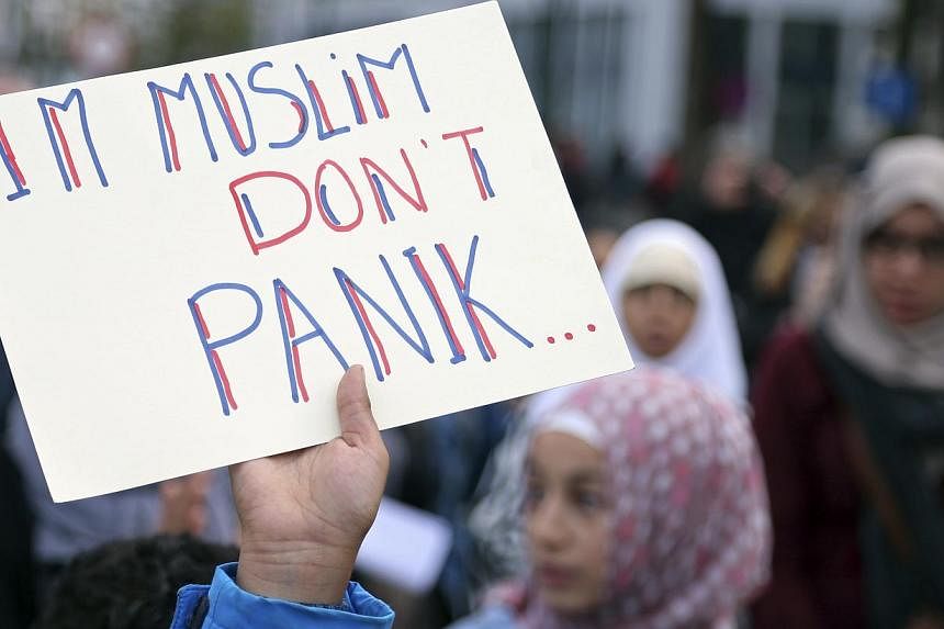 A demonstrator holds up a sign reading "I'm Muslim don't panic" during a protest against Islamophobia in front of the Brussels' Justice Palace on Oct 26, 2014. -- PHOTO: REUTERS&nbsp;