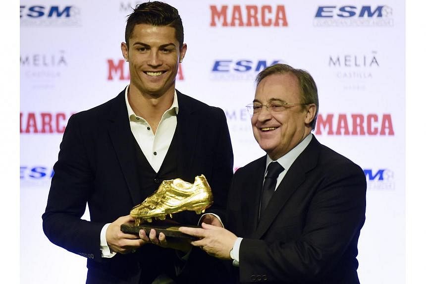 Real Madrid's Portuguese forward Cristiano Ronaldo (left) receives from Real Madrid's president Florentini Perez the 2014 Golden Boot, awarded to the European football competition's best goal scorer over the 2013-2014 season, in Madrid on Nov 5, 2014