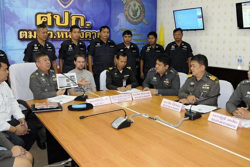 Hans Fredrik Lennart Neij (centre), a co-founder of the Swedish file-sharing website, The Pirate Bay, is surrounded by police officers at the immigration office in Nong Khai province on Nov 4, 2014.&nbsp;The Swedish co-founder of the Pirate Bay websi