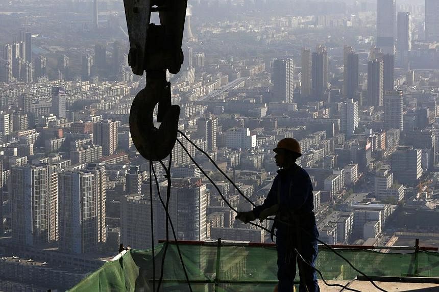 A worker operates at a construction site on the 68th storey of a building in Shenyang, Liaoning province on October 16, 2014. -- PHOTO: REUTERS