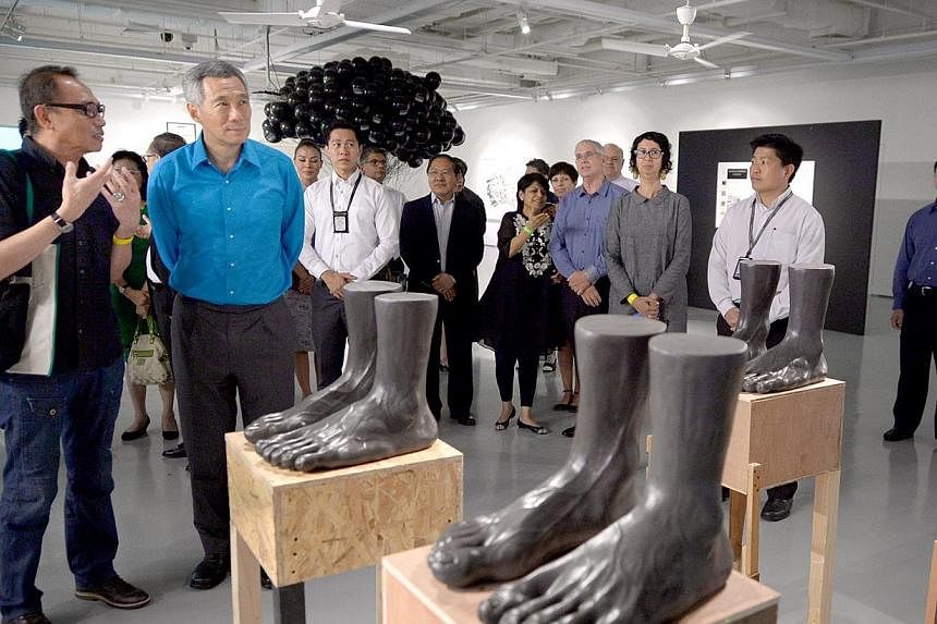 PM Lee Hsien Loong views Vincent Leow's (left) work "Feet Remembered" during LASALLE College of the Arts' 30 year anniversary celebration at LASALLE College, Nov 11, 2014. The&nbsp;arts and culture are an integral part of Singapore which the country 