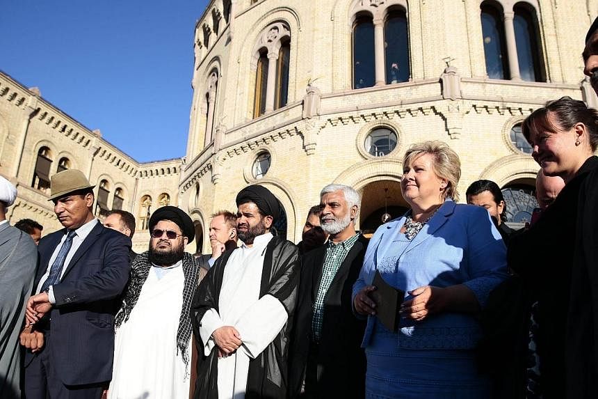 Norway's Prime Minister Erna Solberg (third right) stands next to Norwegian Muslims during a demonstration against Islamic State in Iraq and Syria (ISIS) extremists in front of the Norwegian Parliament building in Oslo on Aug 25, 2014.&nbsp;Norway's 