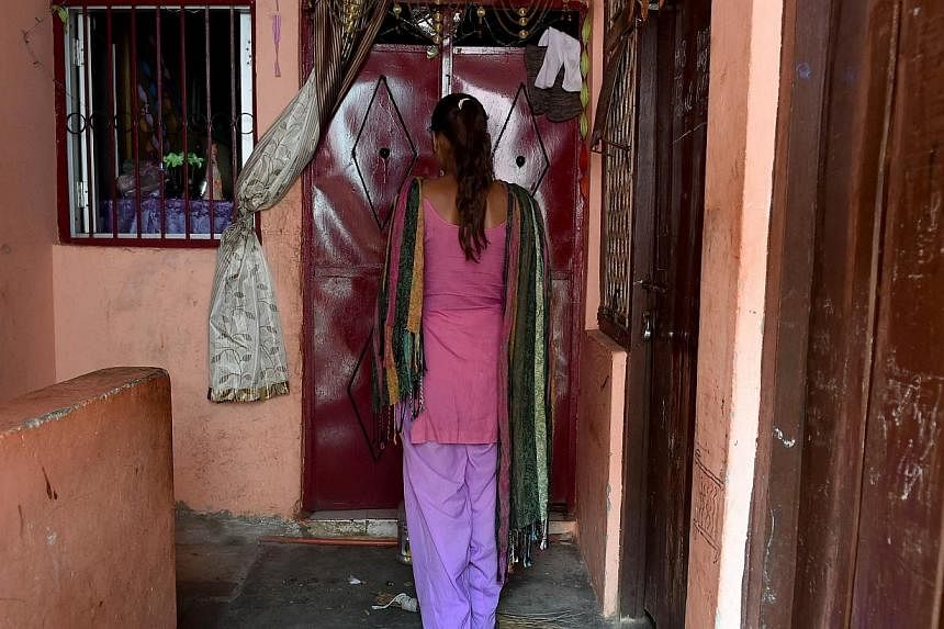 A teenage school student rape victim stands in front of the entrance to the room that she and her parents rent in a slum neighborhood in northeast New Delhi on Nov 5, 2014.&nbsp;An Indian man who tortured and killed his daughter's alleged rapist befo