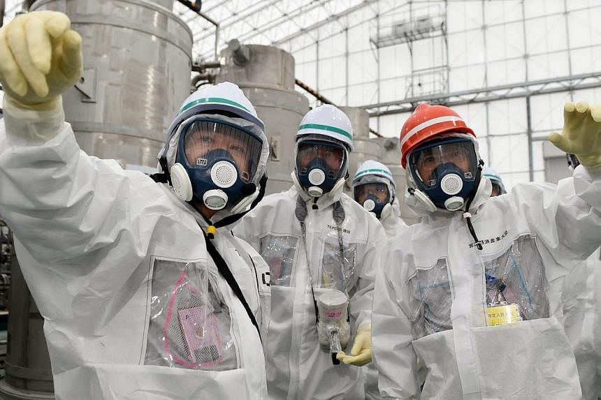 Japan's new Economy, Trade and Industry Minister Yoichi Miyazawa (right), wearing a protective suit and a mask, inspects the Tokyo Electric Power Co. (TEPCO)'s tsunami-crippled Fukushima Daiichi nuclear power plant in Fukushima prefecture, in this ph