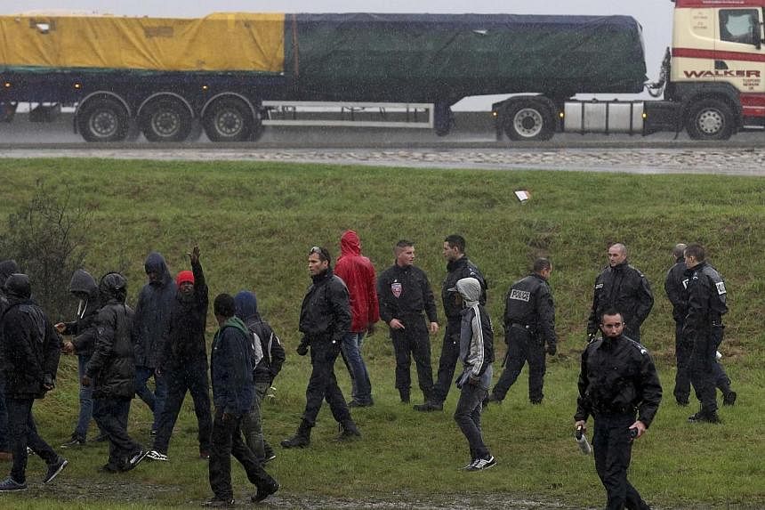 French police prevent a group of migrants from jumping onto lorries on their way to the ferry terminal in Calais on Oct 29, 2014.&nbsp;British officials should be sent to Calais to deter a tide of illegal migrants hoping to cross the English Channel,