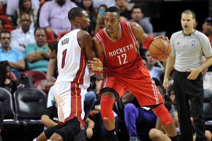 Houston Rockets center Dwight Howard (12) is pressured by Miami Heat forward Chris Bosh (1) during the second half at American Airlines Arena.&nbsp;The unbeaten Houston Rockets continued their sizzling start to the National Basketball Association sea